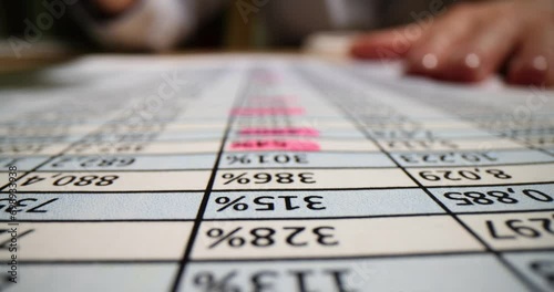 Accountant circling numbers in table on paper with pink marker closeup 4k movie slow motion