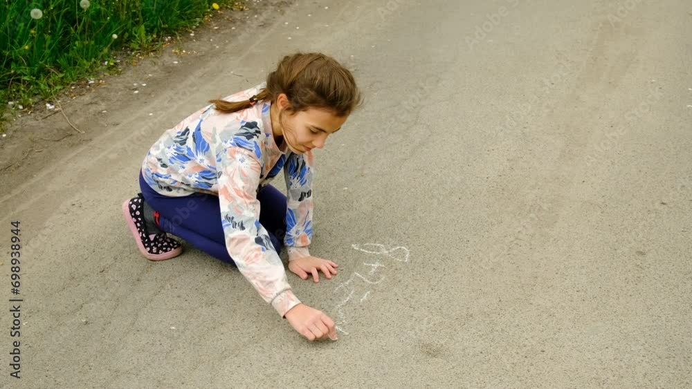 a child writes mathematical examples on the asphalt. Selective focus. a child writes mathematical examples on the asphalt. Selective focus.