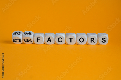 External or internal factors symbol. Turned cubes, changes words external factors to internal factors. Beautiful orange background, copy space. Business, internal or external factors concept.