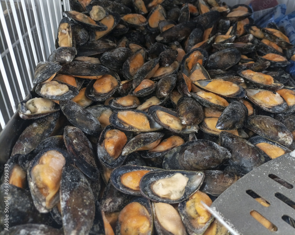 Frozen mussels on a self shopping in a market. Iced mussel meat as ingredient of protein omega-3 healthy eating and tasty seafood recipes. Cooking shellfish. Frozen mussels on a self shopping in a market. Iced mussel meat as ingredient of protein omega-3 healthy eating and tasty seafood recipes. Cooking shellfish.