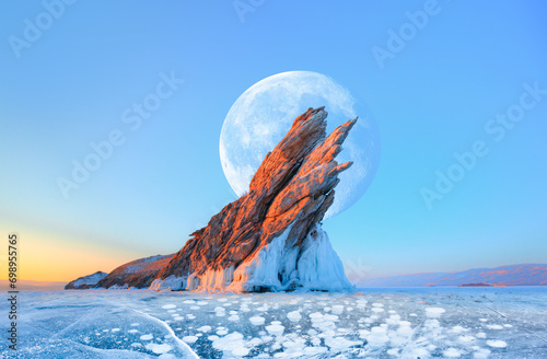 Ogoy island on winter Baikal lake with transparent cracked blue ice with full moon at sunrise - Baikal, Siberia, Russia "Elements of this image furnished by NASA"