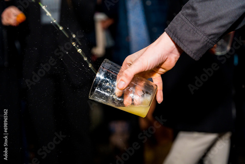 Hand holding a glass of apple cider at an event in a cider house, Basque Country photo