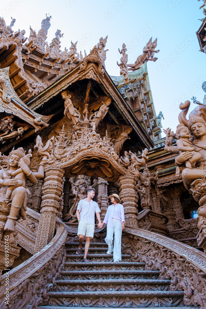 A couple visit The Sanctuary of Truth wooden temple in Pattaya Thailand