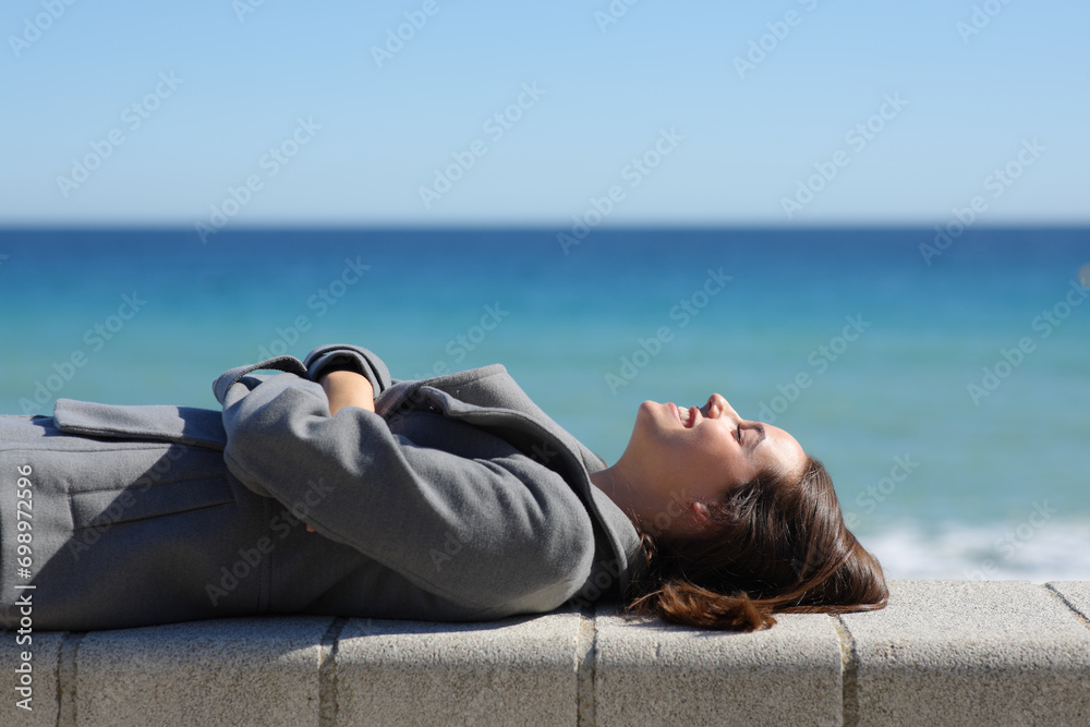 Happy woman resting on the beach in winter Happy woman resting on the beach in winter