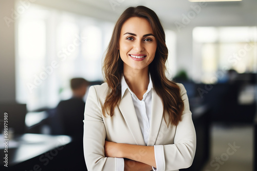 Free Download Portrait of successful and happy businesswoman, office worker smiling and looking at camera with crossed arms, working inside modern office. - GFXLoad