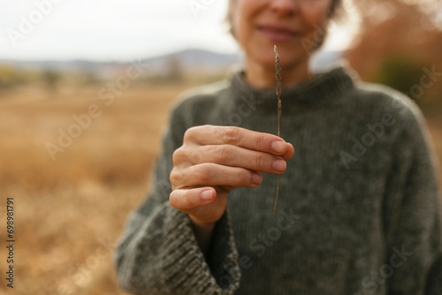 Mature woman holding twig in hand photo