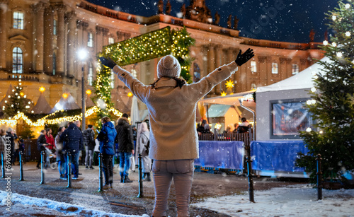 Photography A happy tourist woman in front of a illuminated Christmas market in Berlin, Germ
