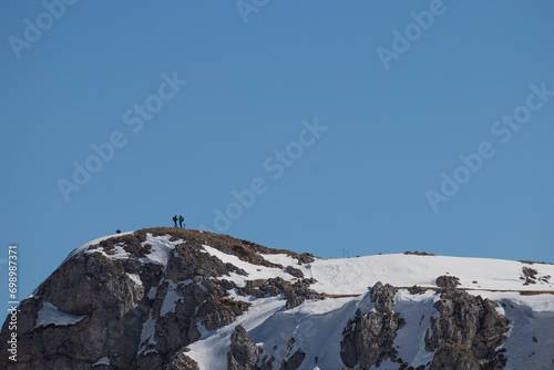 Explorers trek through rugged terrain.