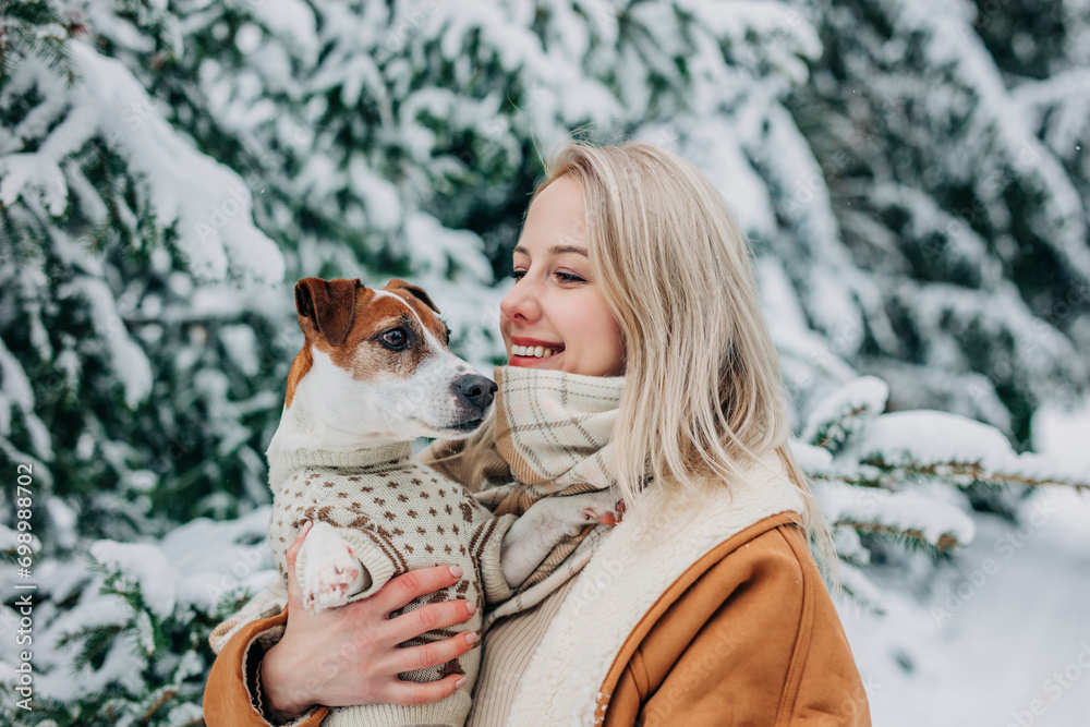 Happy woman with blond hair holding dog in arms Happy woman with blond hair holding dog in arms