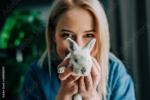 Woman holding Easter bunny in front of face at home photo