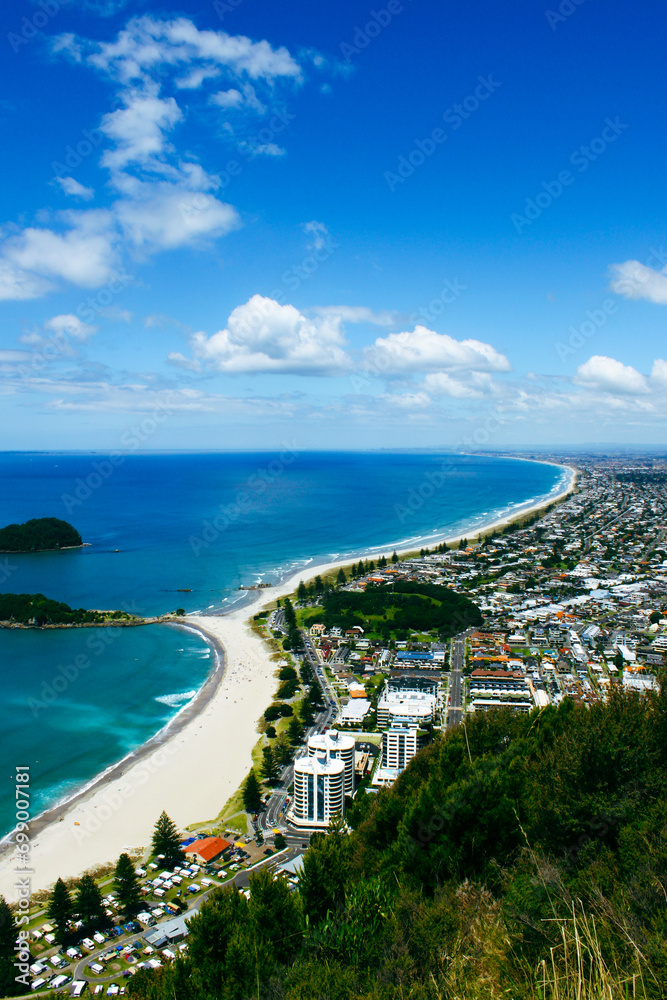 Landscape scenario of a bay with sandy white beach and turquoise sea. Maunganui beach and Moturiki Island , Tauranga, New Zealand. Travel destination