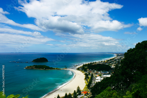 Landscape scenario of a bay with sandy white beach and turquoise sea. Maunganui beach and Moturiki Island , Tauranga, New Zealand. Travel destination photo