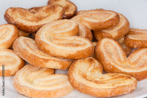 Photos Heap of puff pastry butterfly cookies, side view close-up