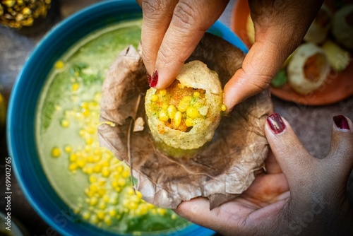 Golgappa and Puchka, Woman hand holding panipuri indian ball snack famous delicious food India. North Indian street food Indian panipuri snack.
 photo