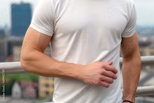 Close-up of a man in a blank t-shirt standing outside with a modern urban background mockup