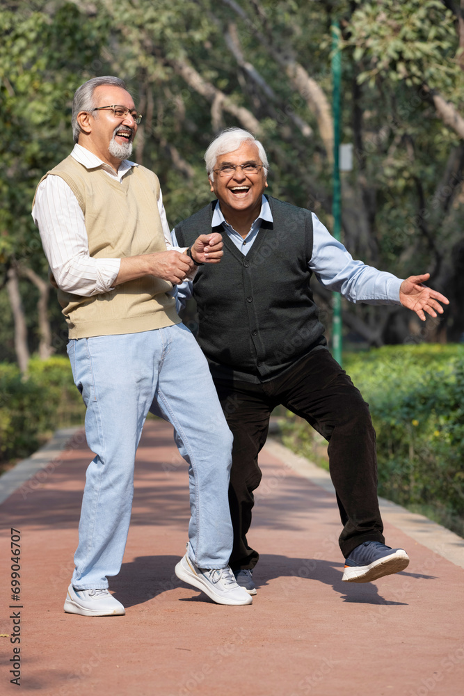 Old male friends having fun admiring nature at park Old male friends having fun admiring nature at park