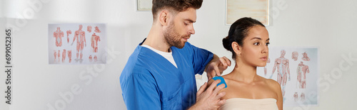 good looking bearded doctor putting kinesiological tapes on his patient during appointment, banner photo