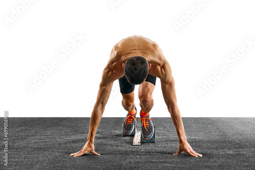Young athletic man, professional runner preparing before running from low start against white studio background. Concept of sport, active lifestyle, action, victory. Copy space. Ad