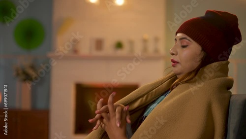 indian women shivering from freezing cold at home during winter holidays - concept of climate change, tranquility and frosty