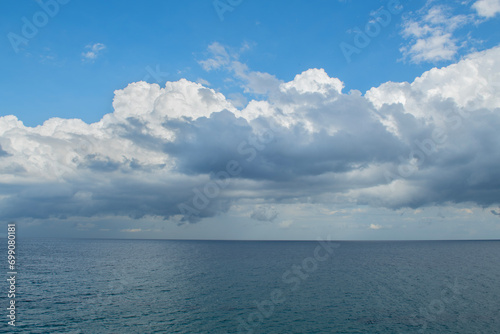 Looking at the sea from the coastal green area. Looking at the sea from the rocks on a cloudy day. Sea view from red cliffs.Cyprus coast.