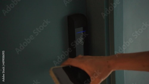 Close-Up hand of woman using smart phone touch to unlock the hotel room door. Digital or keyless to authenticate. Wireless technology. photo