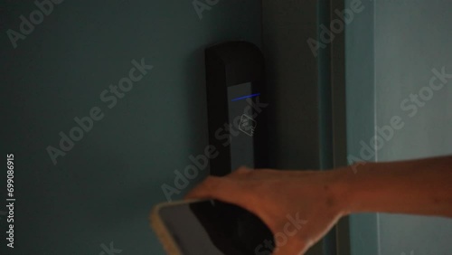 Close-Up hand of woman using smart phone touch to unlock the hotel room door. Digital or keyless to authenticate. Wireless technology.