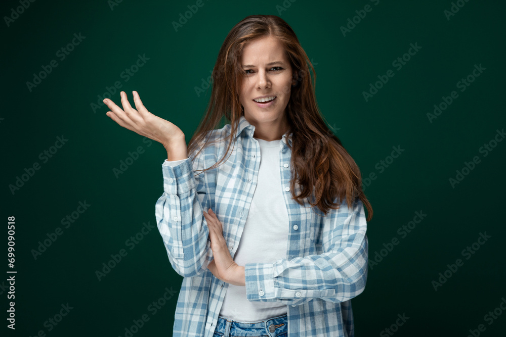 Fototapeta premium Portrait of a well-groomed young lady with natural brown hair on a green background