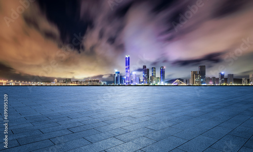 Empty square floors and city skyline with modern buildings scenery at night