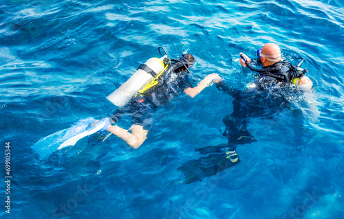 diver instructor with a girl tourist swim in the Red Sea
