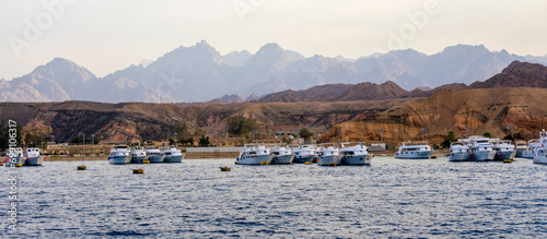 cruise boats near the rocky shore