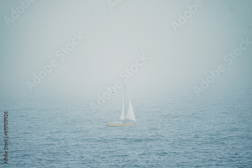 Sailboat in the ocean in the dust of calima on the Canary Islands, Spain.