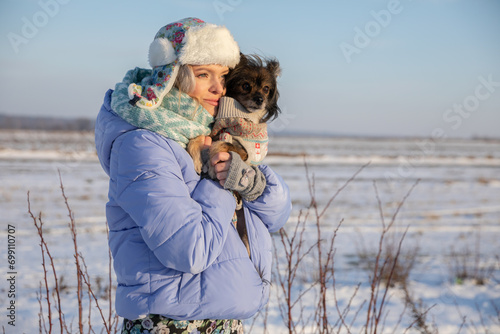 The girl cuddles her face into the fluffy fur of her dog. photo