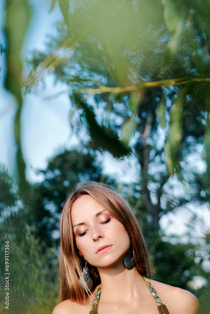 Outdoor portrait of young beautiful woman with long hair against green nature Outdoor portrait of young beautiful woman with long hair against green nature