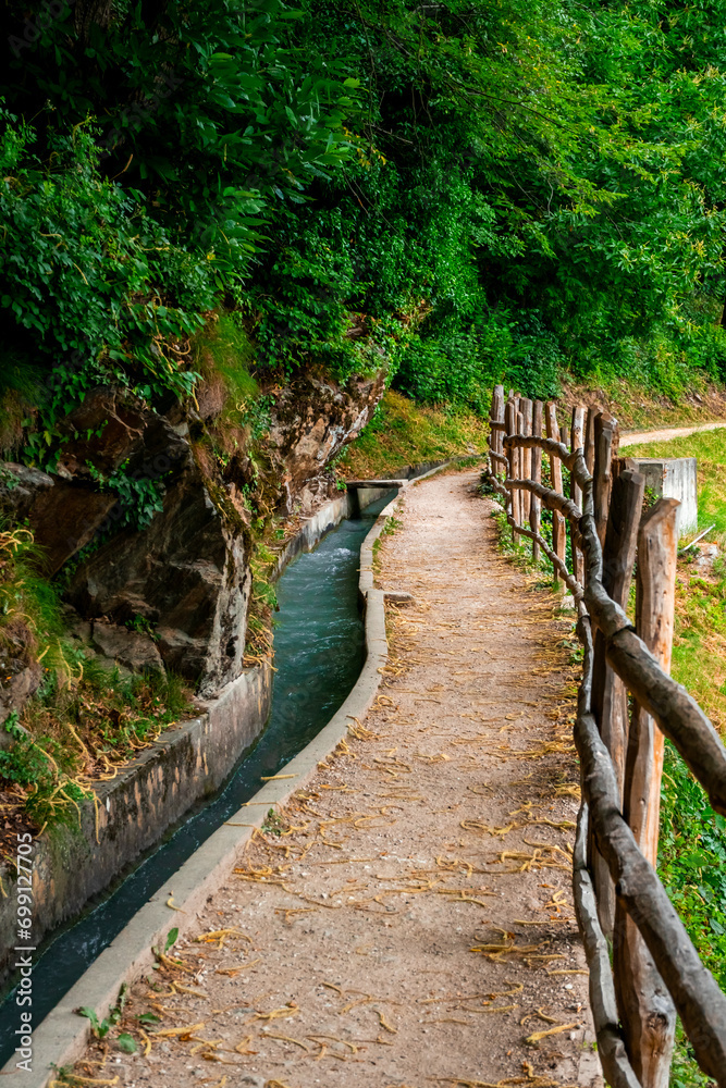 Fototapeta premium Hiking along the Marlinger Waalweg near Meran in South Tyrol Italy. With some Views over wineyards, the City of Meran, Marling and other Villages