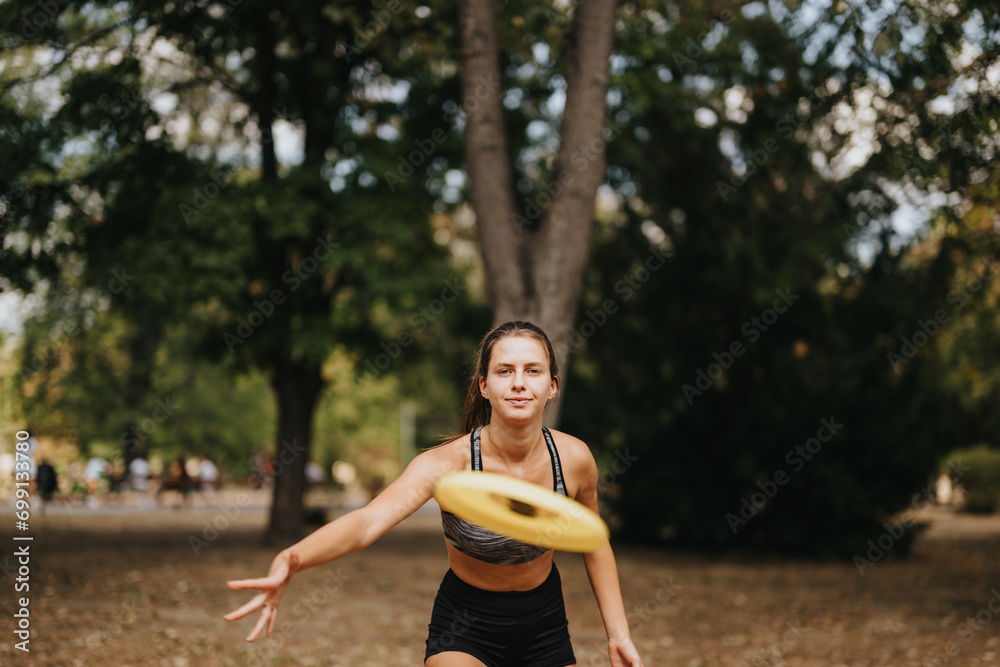 Sports girl enjoying playing frisbee in the park. Lovely sports girl throwing frisbee to the camera. Sports girl enjoying playing frisbee in the park. Lovely sports girl throwing frisbee to the camera.