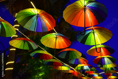 фотографія Row of hanging colorful umbrellas against the background of the evening sky