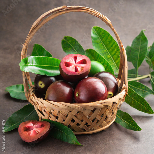 fresh kokum or garcinia indica fruit from india isolated over white or in cane basket with leaves. selective focus photo