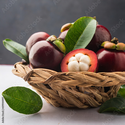 fresh kokum or garcinia indica fruit from india isolated over white or in cane basket with leaves. selective focus photo