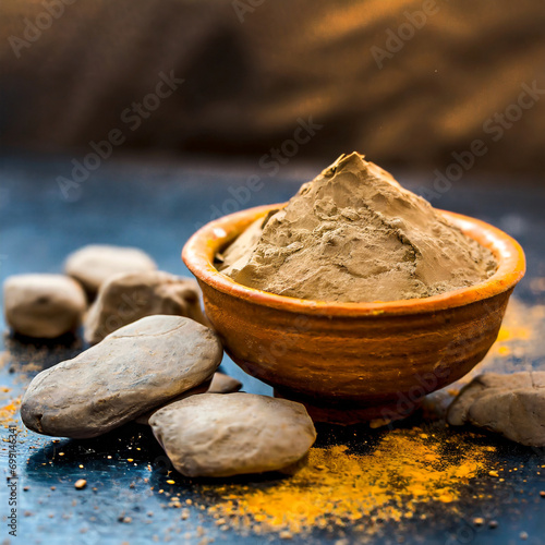 Fuller'S Earth Clay OR Multani mitti in a bowl along with raw stones and mortar photo