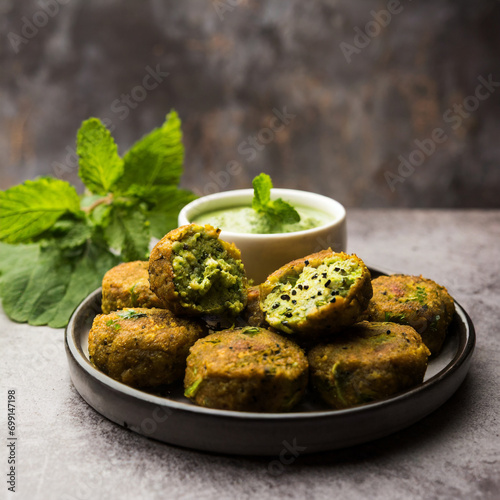 hara bhara kabab or kebab is indian vegetarian snack recipe served with green mint chutney over moody background photo