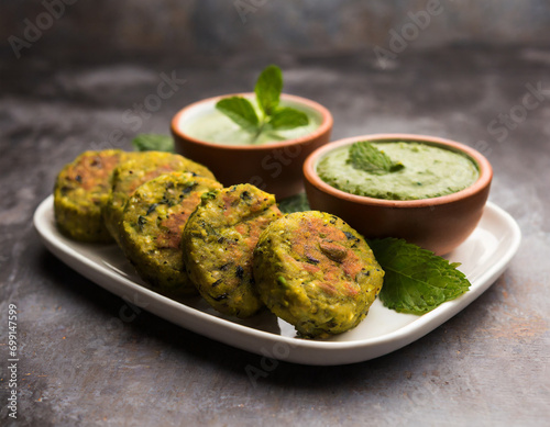 hara bhara kabab or kebab is indian vegetarian snack recipe served with green mint chutney over moody background photo