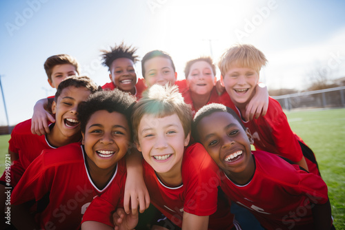 Smiling junior football team hugging on field. Generative AI