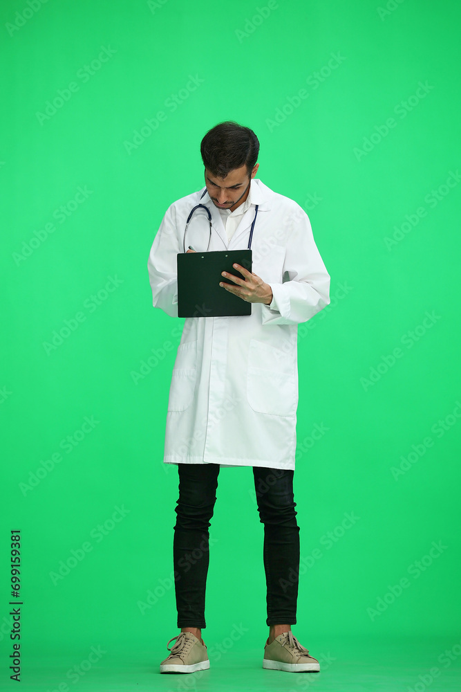 male doctor on a green background. writes in full length male doctor on a green background. writes in full length