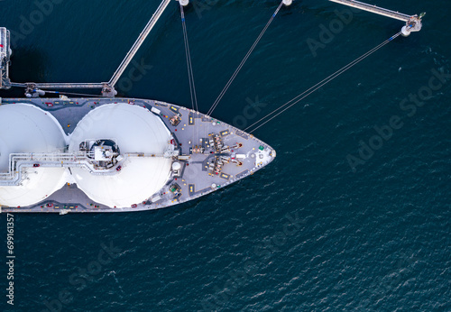Aerial top down of Liquified Natural Gas LNG carrier moored to a small gas terminal. Top down view of a ship bow. Fuel crisis. Sanctions