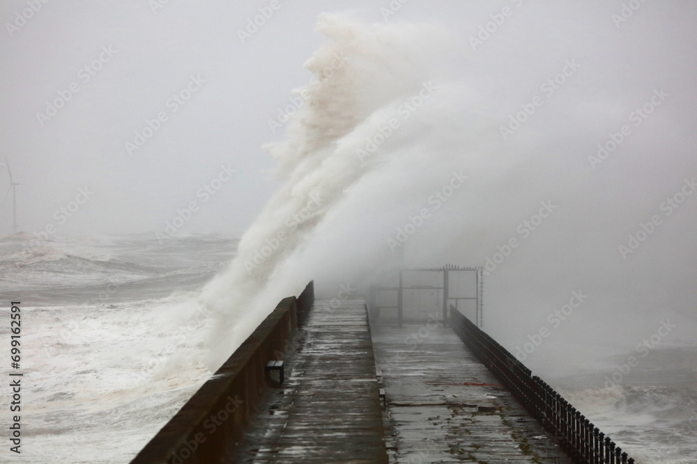 Huge Waves crashing a stone pier during a storm at Hartlepool Headland, County Durham, England, UK. - obrazy, fototapety, plakaty 
