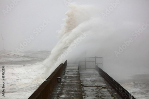 Huge Waves crashing a stone pier during a storm at Hartlepool Headland, County Durham, England, UK. photo