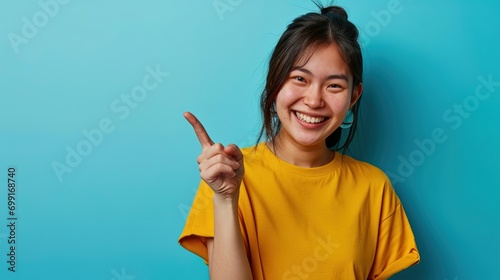 Lucky winner. Cheerful charismatic asian cute urban girl stand yellow t-shirt smiling friendly pointing finger camera choosing, picking person, inviting you team, stand happy blue background photo