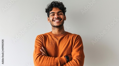 man wearing orange sweater over isolated white background happy face smiling with crossed arms