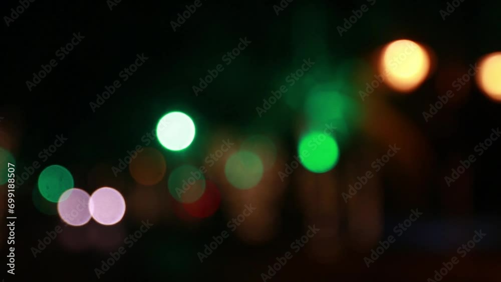 Blurred colored lights with car light passing on the road Blurred colored lights with car light passing on the road