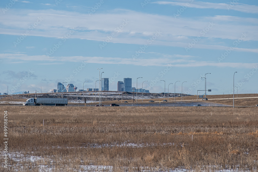 Traffic on Stoney trail with Calgary skyline and mountains in background